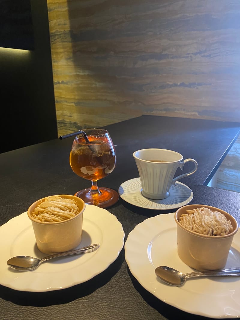 カウンターに並ぶドリンクとコーヒー、2皿のケーキ