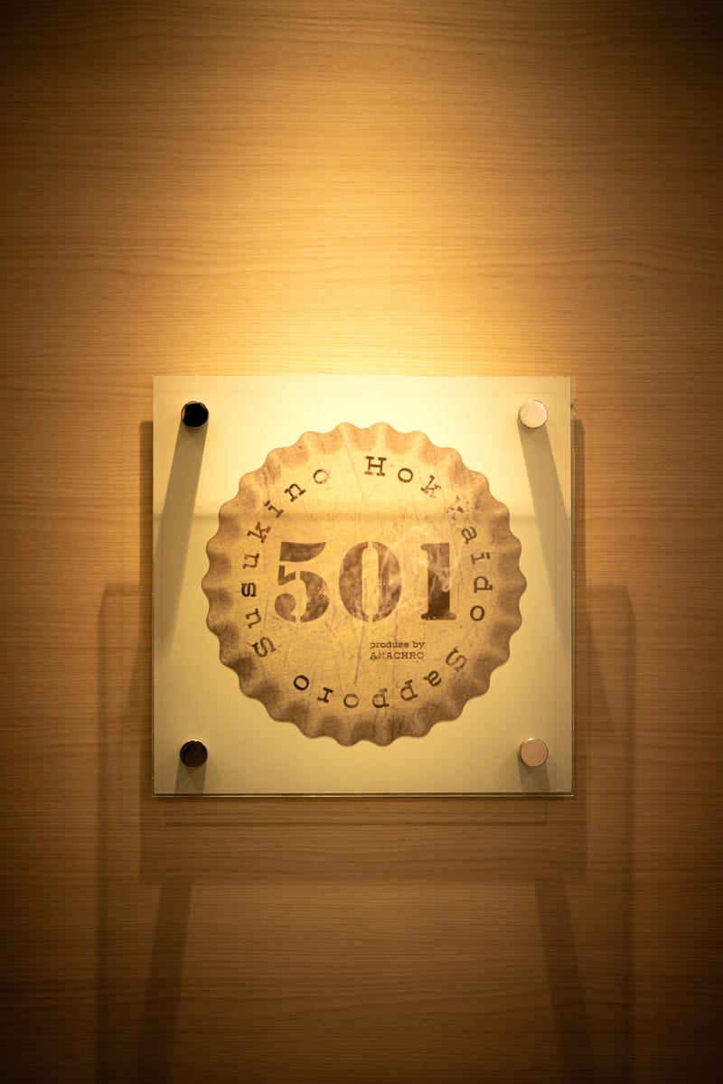 照明に浮かぶ、王冠の形をした501のロゴ看板